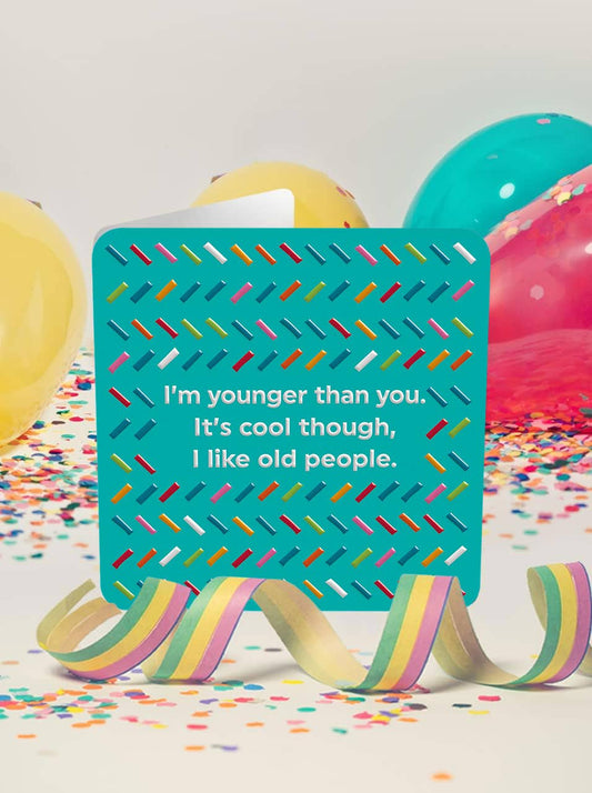 Teal sign with humorous quote on a colorful background with balloons and confetti