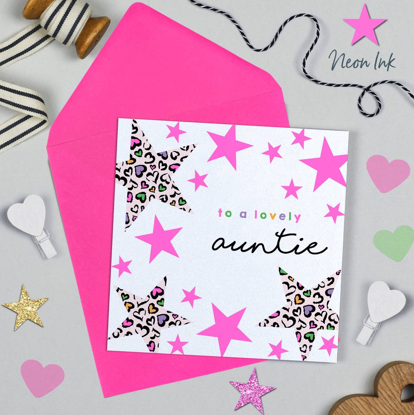 Greeting card for a lovely auntie with pink stars and hearts on a gray background.