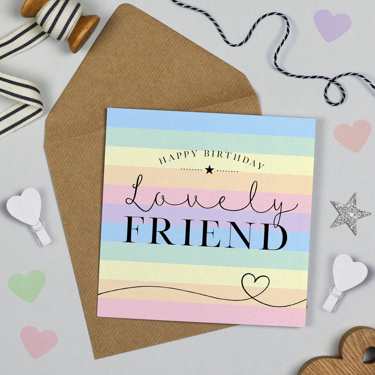 Birthday card for a friend with pastel rainbow stripes and decorative items on a light gray background