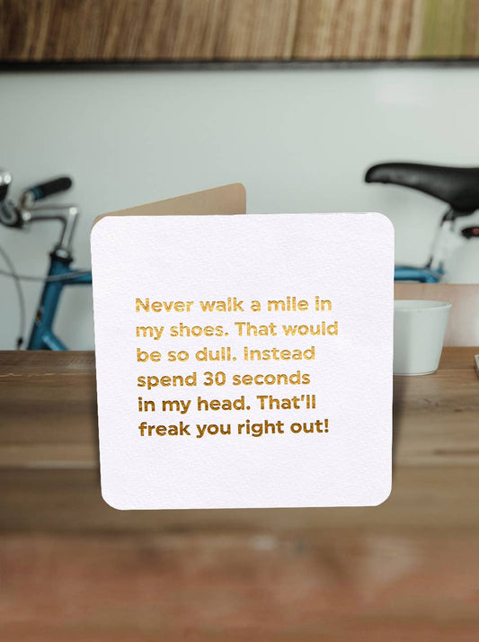 Card with humorous text on a wooden surface with bicycles in the background