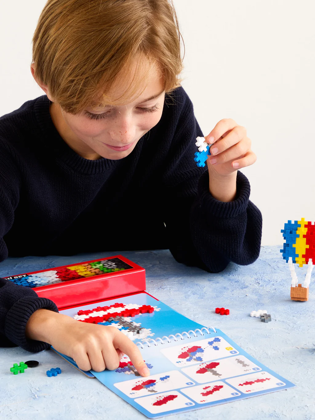 Child playing with a puzzle and building set on a table