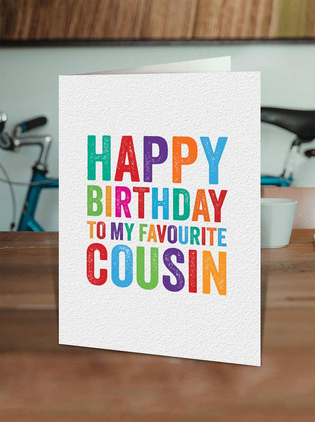 Colorful birthday card for a cousin on a wooden surface with a blurred background