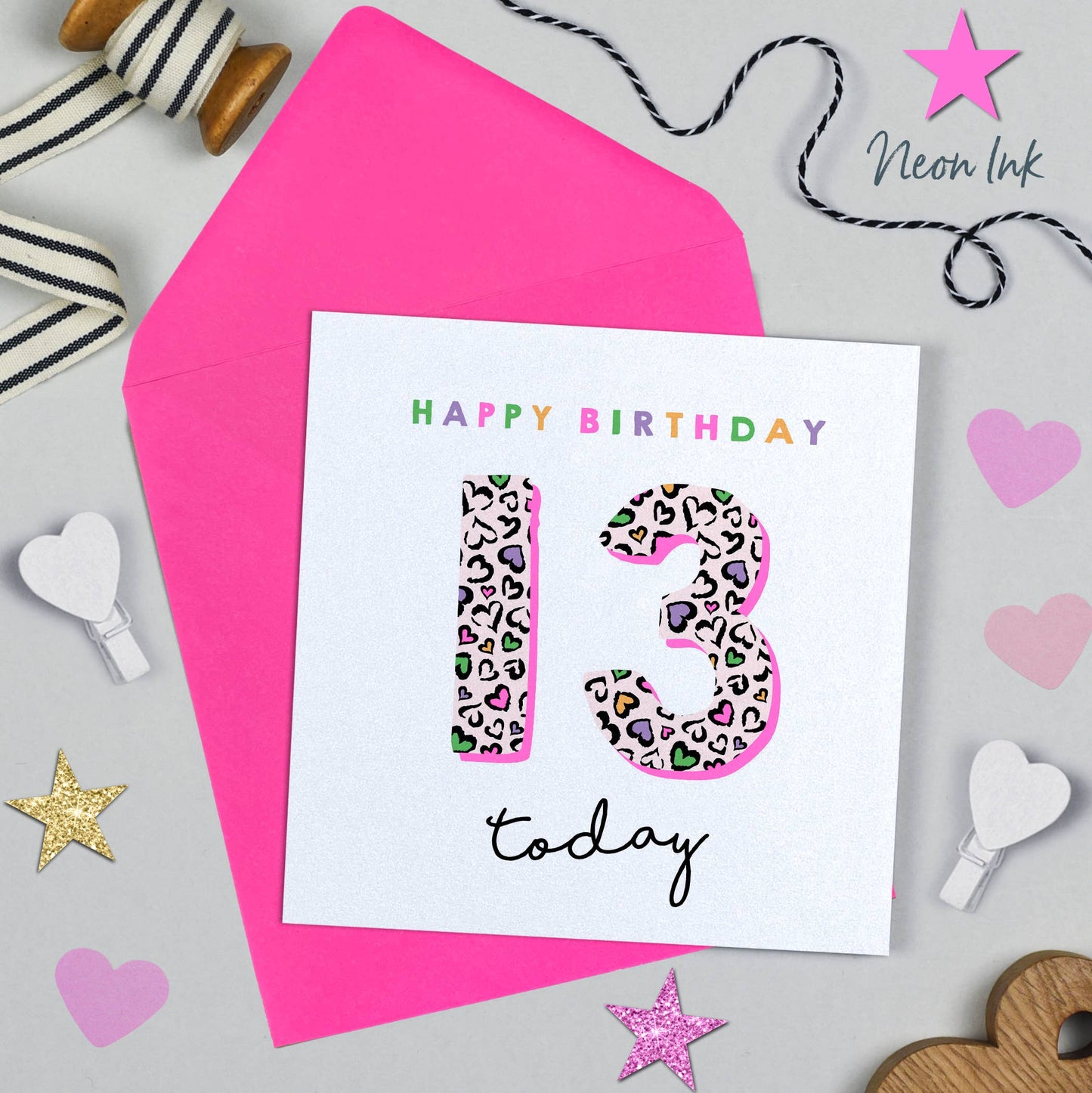 Birthday card with leopard print numbers '13' on a pink background with decorative items.
