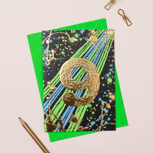 A card with a gold foil age 9 in the middle
