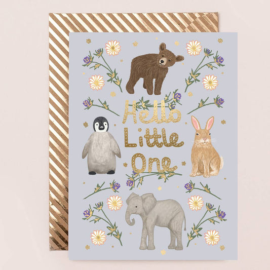 A greeting card with gold foil lettering and illustrations of an elephant, bear, penguin, and rabbit, surrounded by floral designs. The card says 'Hello Little One'.