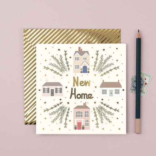 A greeting card with a house and shrub illustration and the text 'NEW HOME' on it, accompanied by a pencil and a stamp on a pink background.