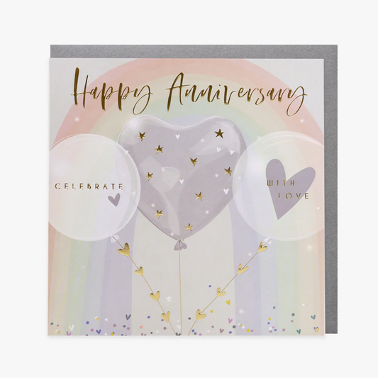 A greeting card with 'Happy Anniversary' text, embossed design, gold foil accents, a balloon illustration, and a rainbow background. The card also features the words 'Celebrate With Love' and has a silver envelope.