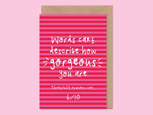 A cheeky Valentine's Day or anniversary greeting card with pink stripes and white text that reads 'Words can't describe how gorgeous you are.
