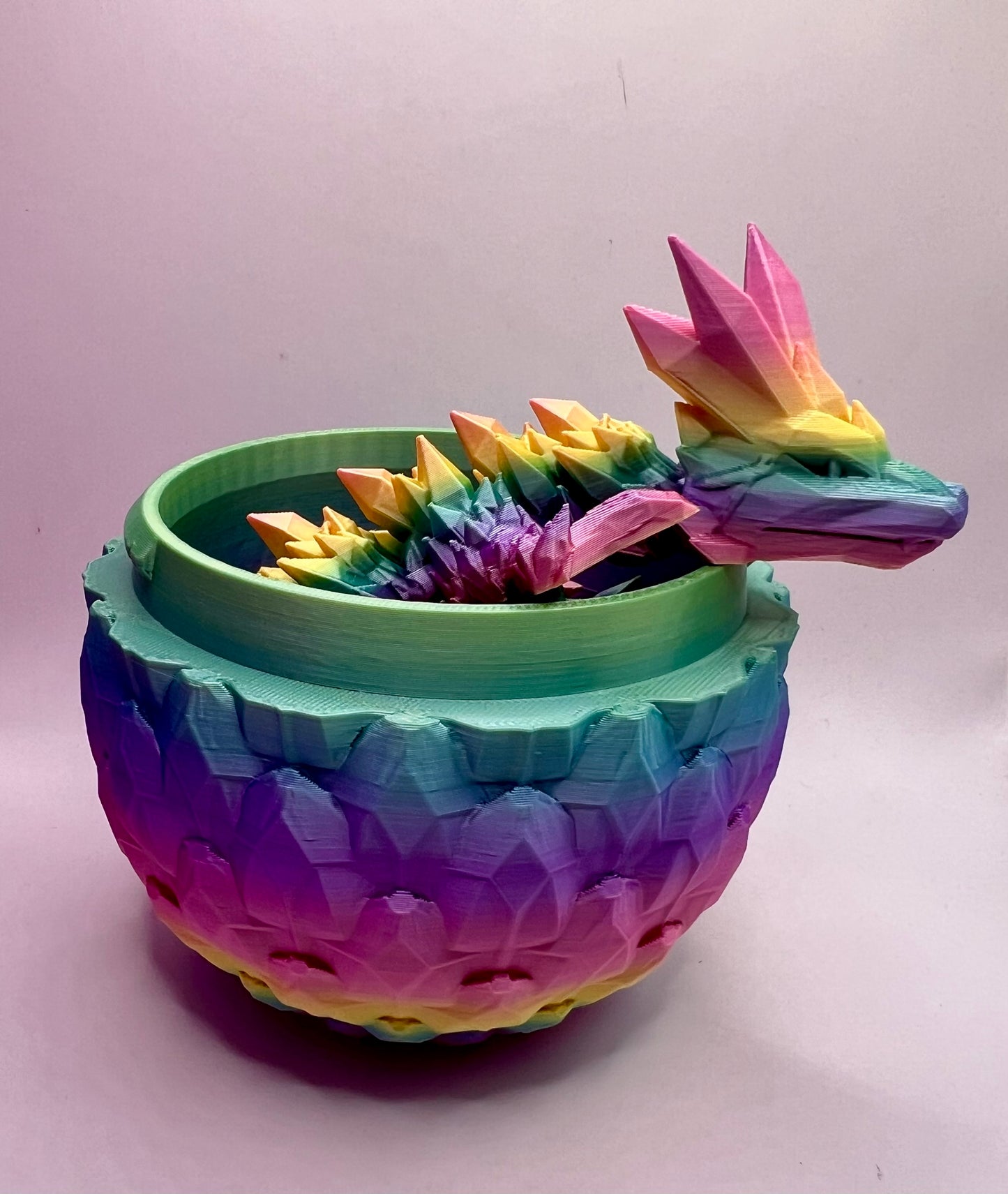 A picture of a rainbow dragon poking out of the bottom of an eg