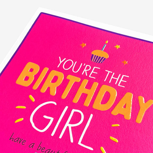 Pink birthday card with colorful text and cupcake illustration on a white background