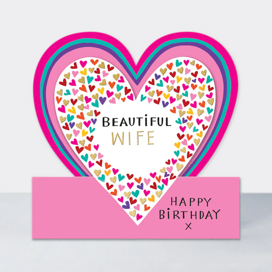 A heart shaped card with the words Beautiful Wife surrounded by many multicoloured small hearts. On the Pink base the words "Happy Birthday" are shown.