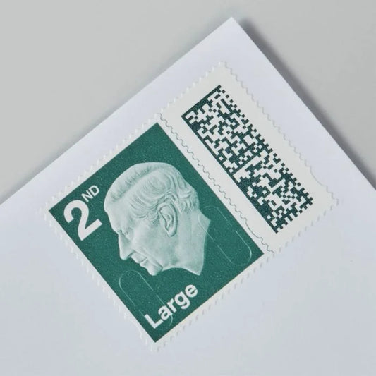 A green royal mail 2nd class stamp with barcode on a white envelope.