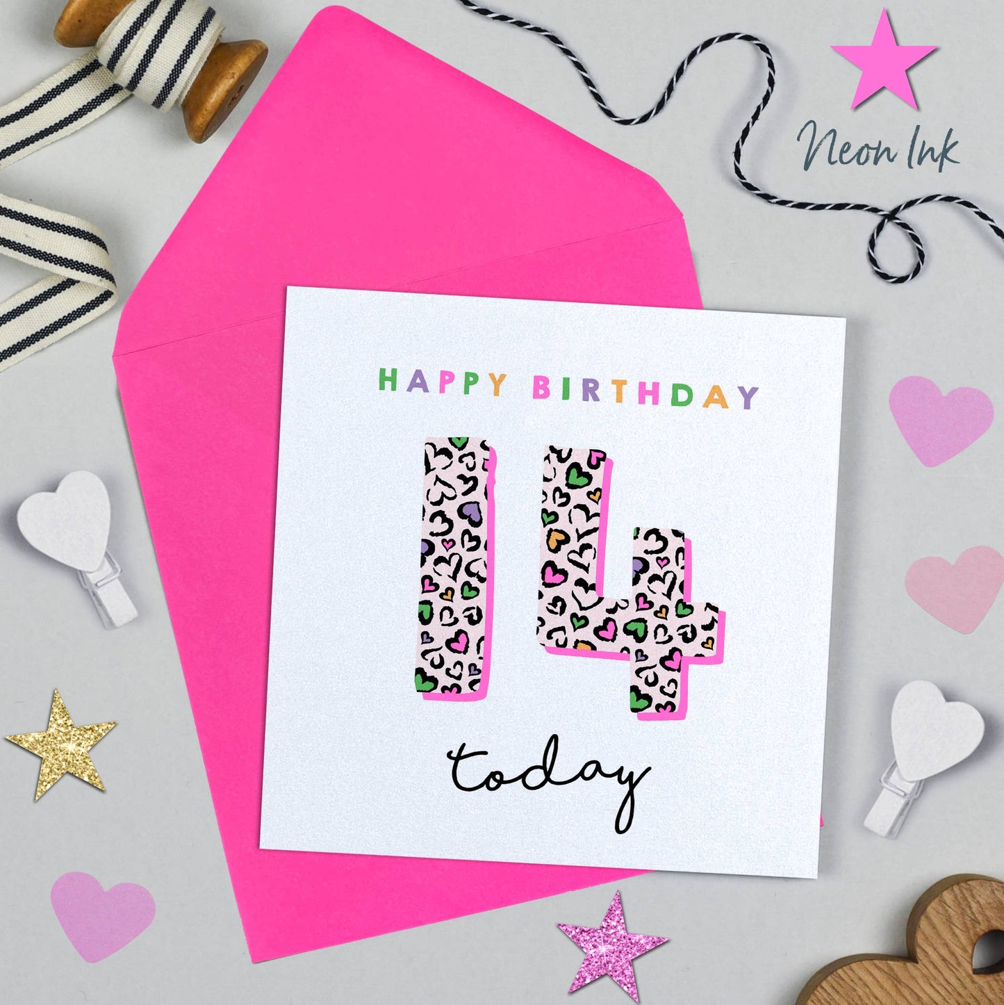Birthday card with leopard print number 14 and 'Happy Birthday' text, surrounded by decorative items on a light gray background.