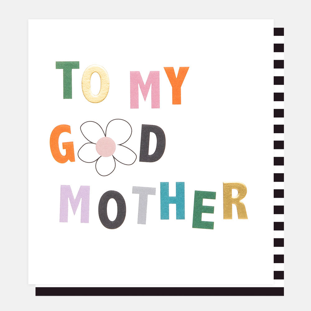 A white card with the words "To my Godmother" on.  There is a white daisy instead of the O in Godmother.  You can see a stripey black and white envelope.