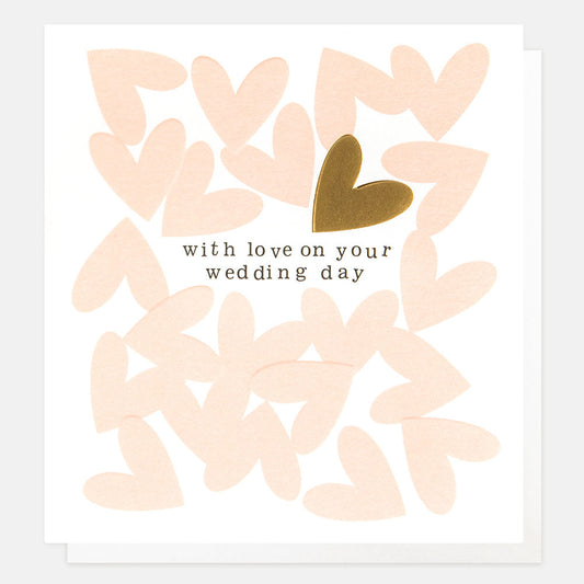  A White card with pink hearts put on top randomly with the text 'with love on your wedding day' and a gold heart above it.