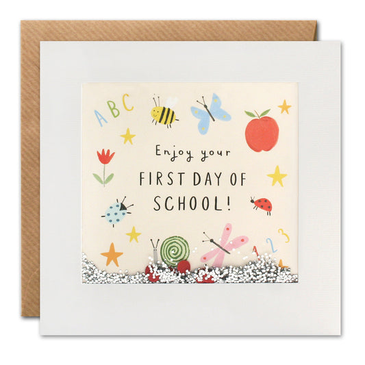 Greeting card with a colorful illustration featuring various school-related items such as a apple, bees, and stars, with the text 'Enjoy your First Day of School!'.
